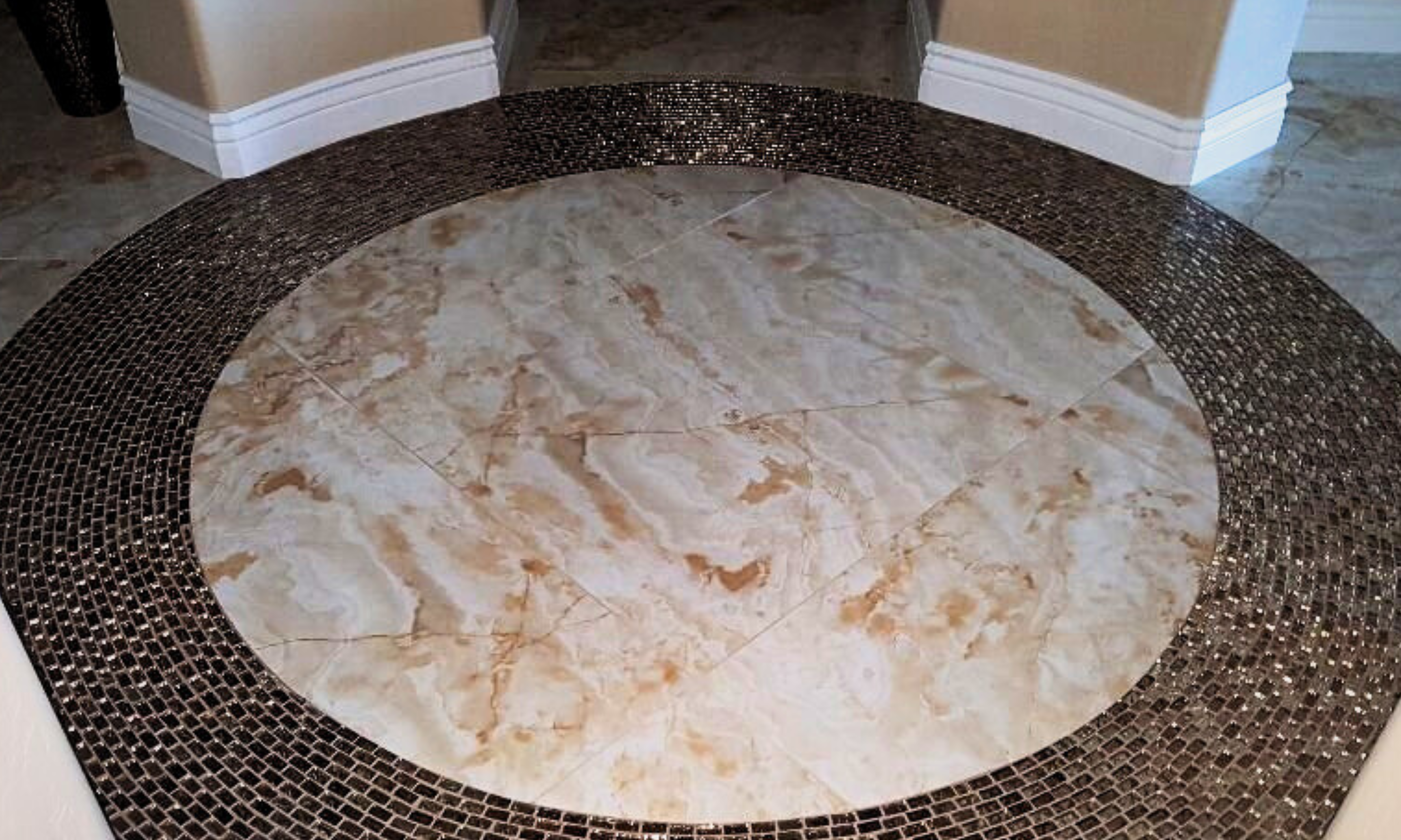 Cooper tiling circle around tan marbled porcelain entryway