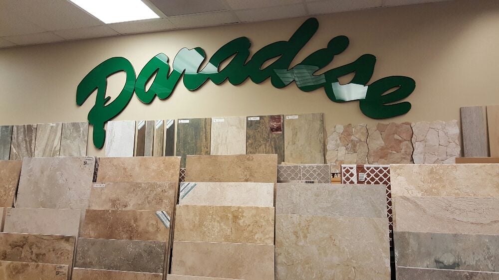 Paradise Tile and Natural Stone green showroom sign with tile samples