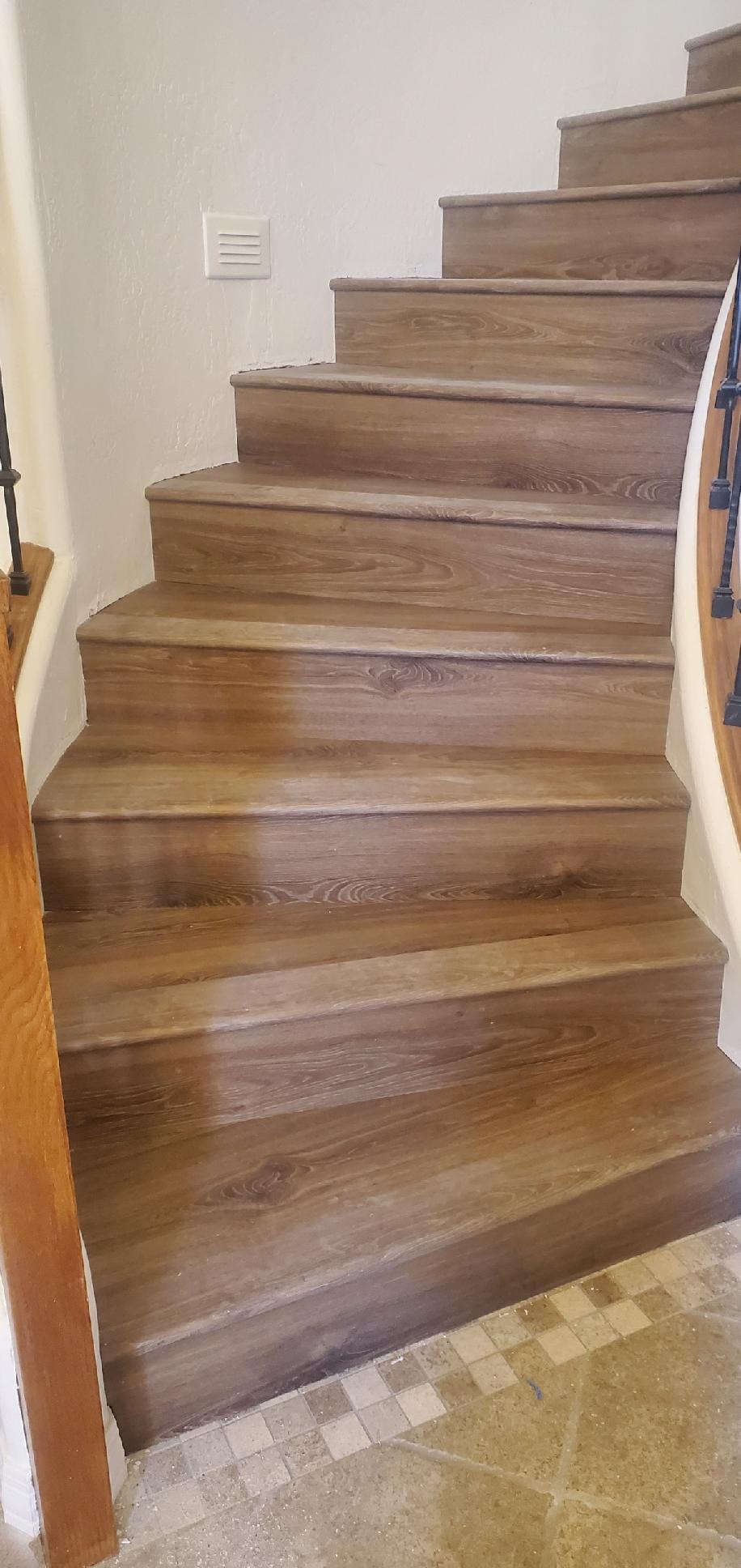 Light brown wood texture vinyl flooring curved staircase with oak banister