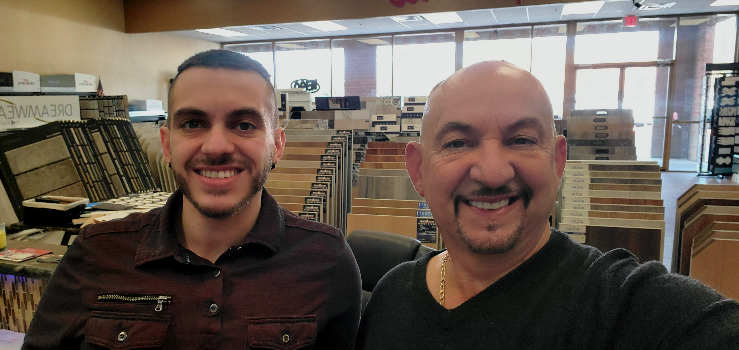 Paradise Tile Owner and Son in Family Run Business, posing for a photo inside the flooring showroom, smiling father and son