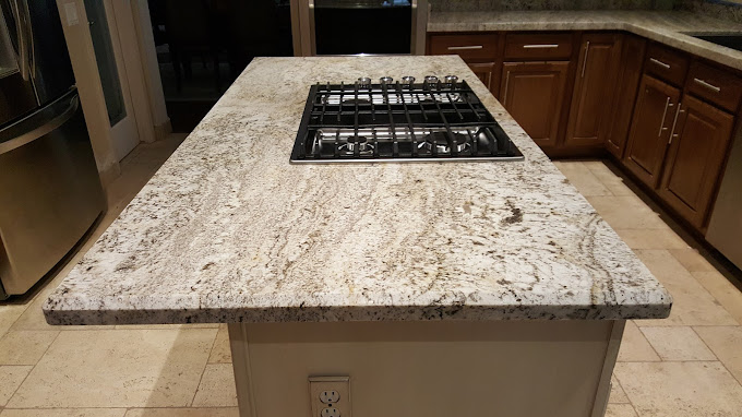 Grey white and black granite coutnertop with stovetop on kitchen island