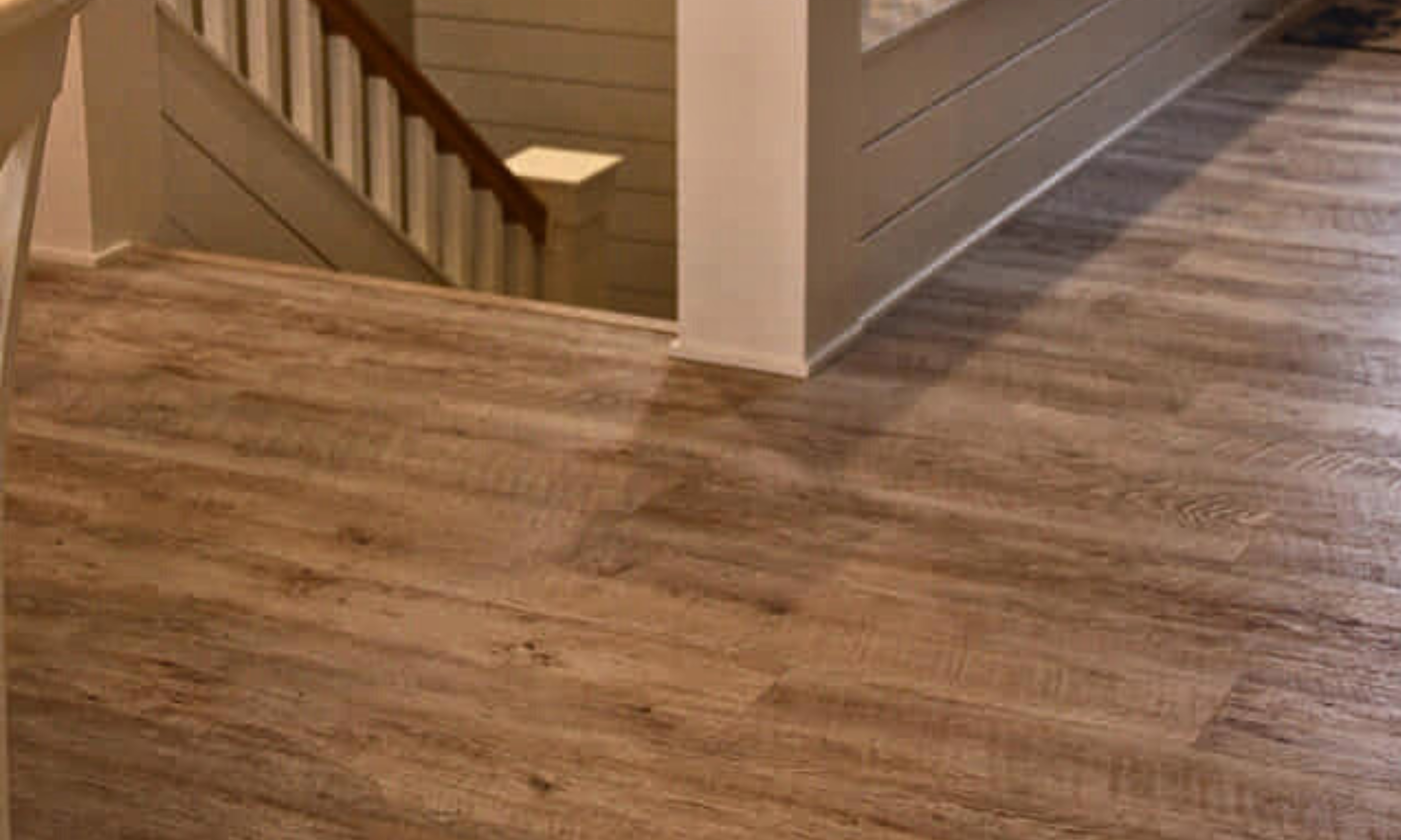 Upstairs landing of staircase with tan and gray vinyl flooring