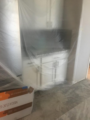 Kitchen buffet covered with plastic wrap to protect from flooring installation process