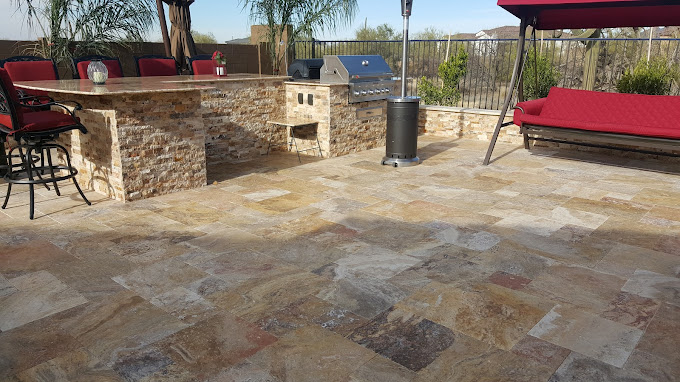 Natural stone tile flooring with custom tile built in grill and outdoor kitchen in Arizona desert
